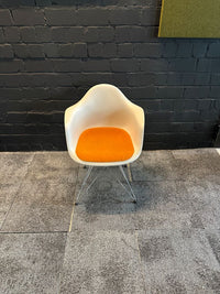 Eames Plastic Armchair DAR mit orangem Sitzkissen