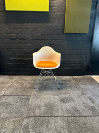 Eames Plastic Armchair DAR mit orangem Sitzkissen